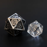 Closeup comparison of hollow metal d20 in silver ingot and translucent standard d20 is about twice the size of the standard d20