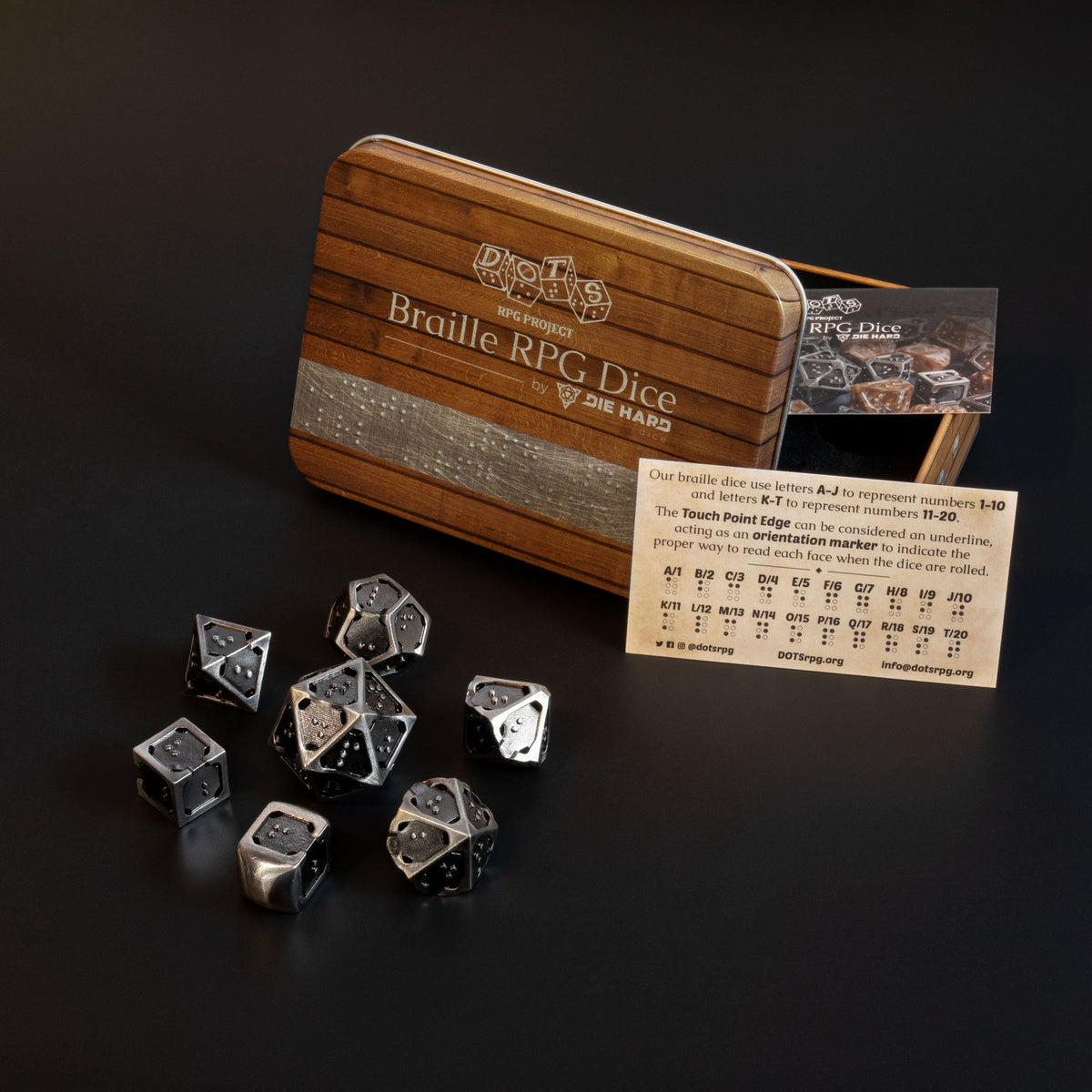 7 piece set of hollow metal braille rpg dice in silver ingot with metal case and sighted braille guide.